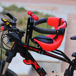 Red front mount child bicycle seat clamped to a mountain bike frame outdoors