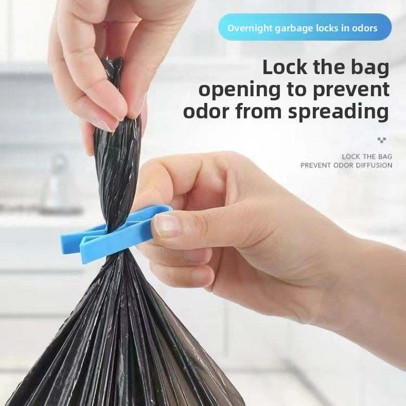 Blue clip sealing the opening of a black garbage bag