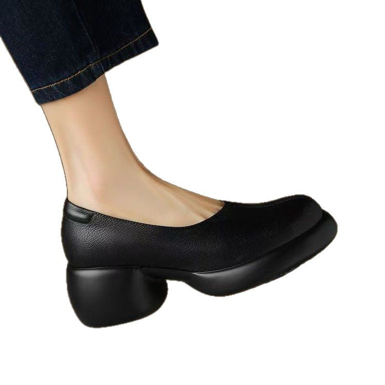 Black PU slip-on pump with chunky heel and platform sole worn with dark jeans on a white background