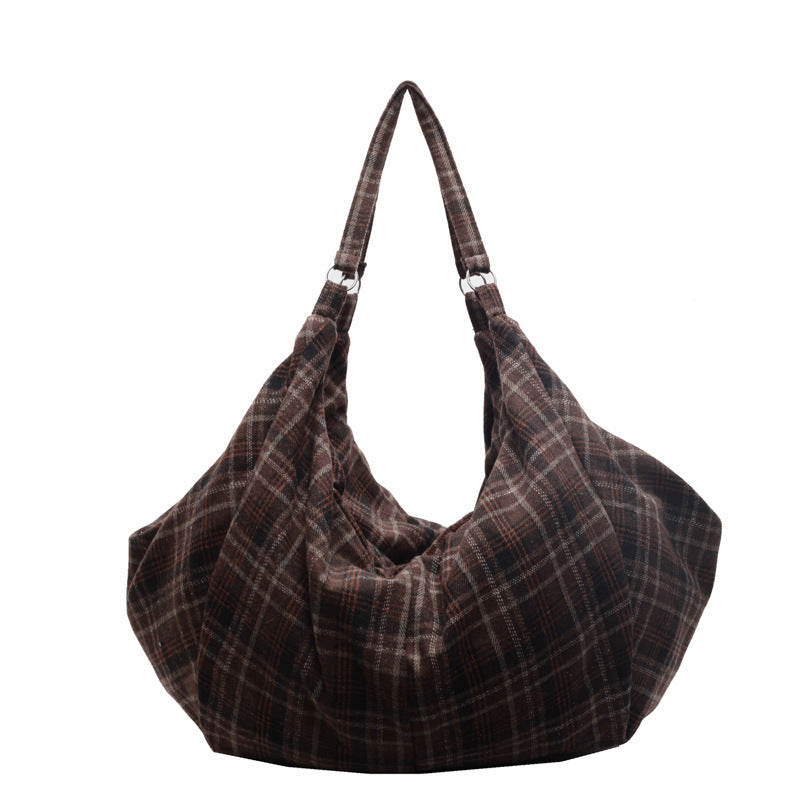 Detail of the checked woolen fabric and sewn seams on the large shoulder tote bag