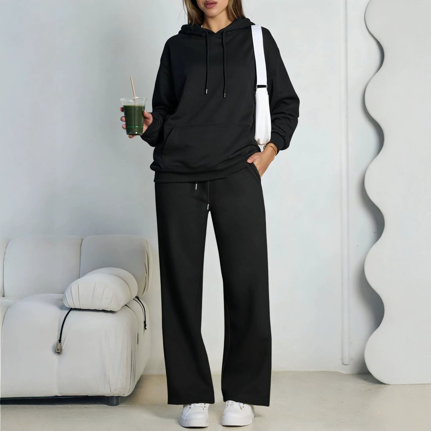 Black fleece hooded sweatshirt and wide-leg sweatpants set worn by a model