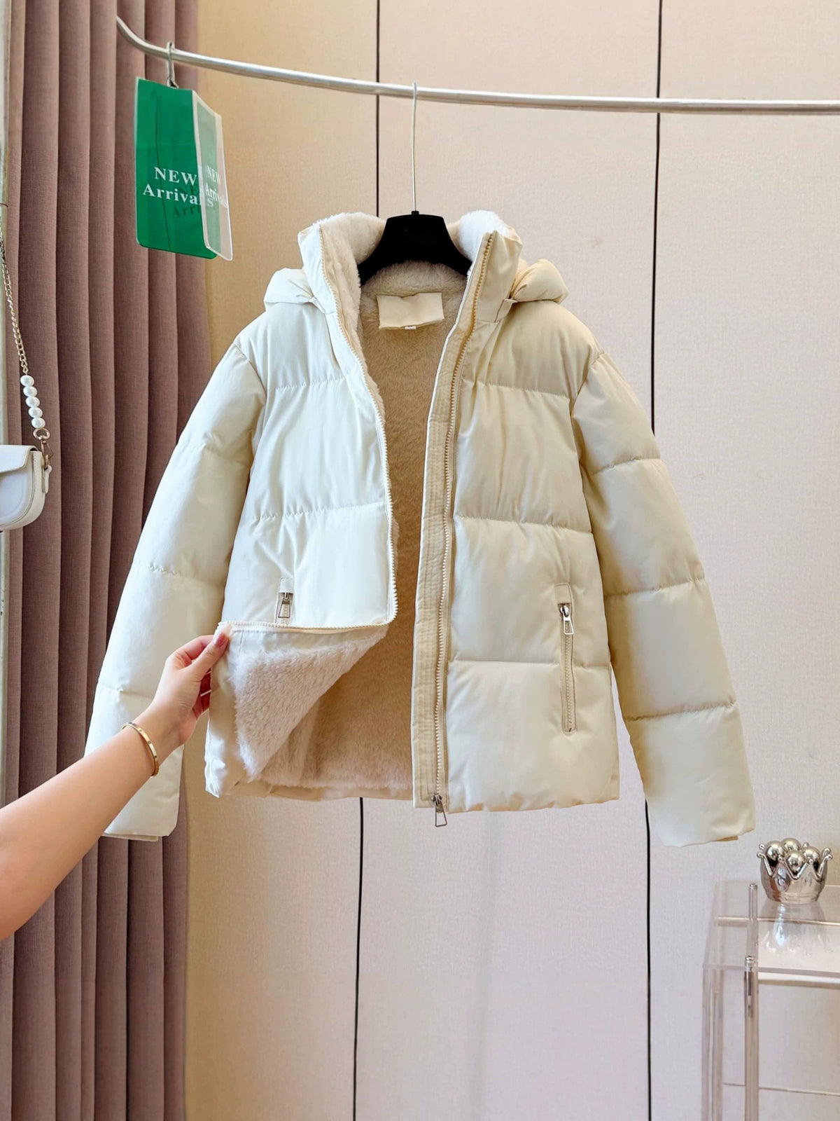 Close view of a zippered front pocket on the quilted short puffer jacket
