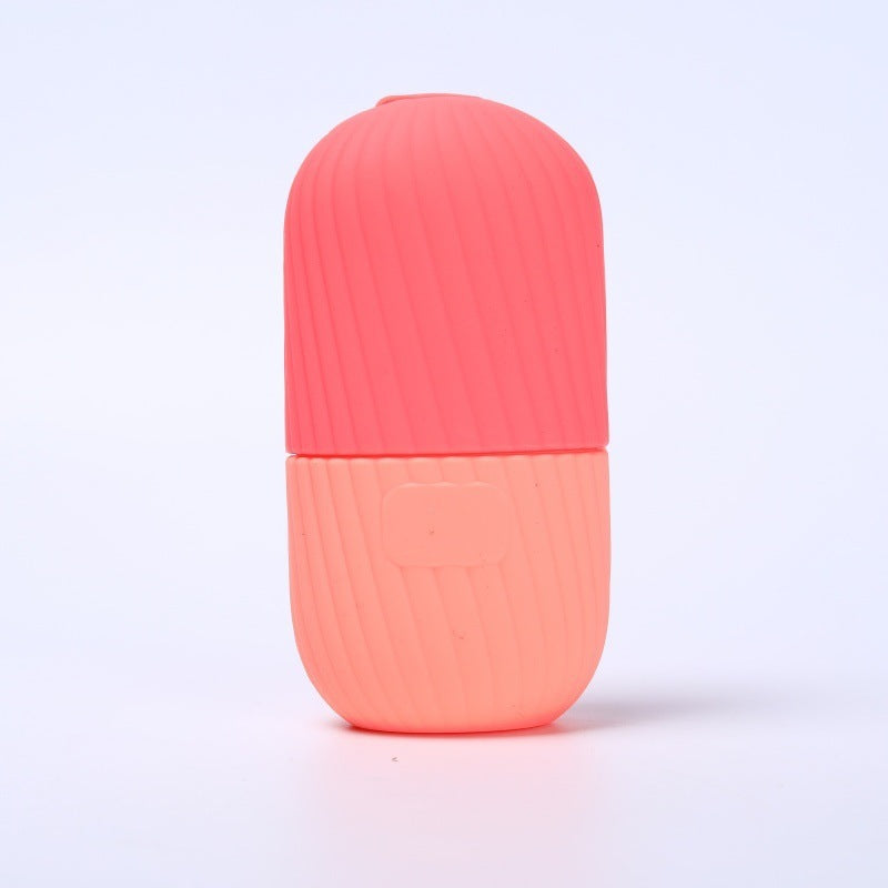 Wine red and pink two tone silicone facial ice tool standing on a light surface