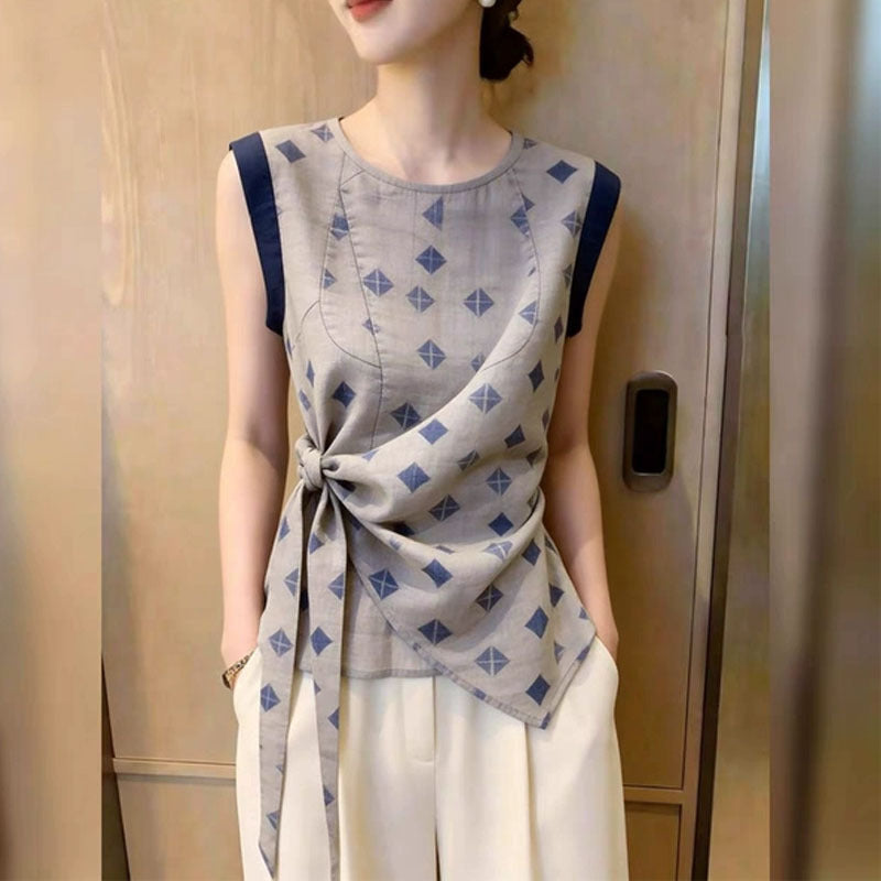 Woman in gray cotton-linen sleeveless blouse with blue diamond print and knotted waist tie