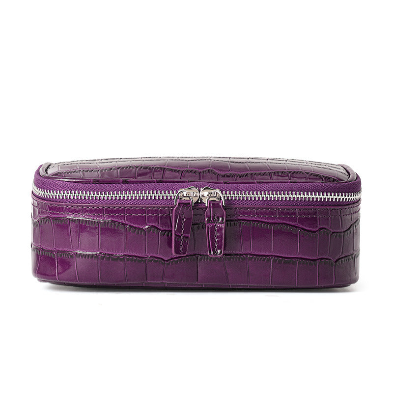 Close front view of the purple crocodile pattern cosmetic bag showing the double zipper tabs