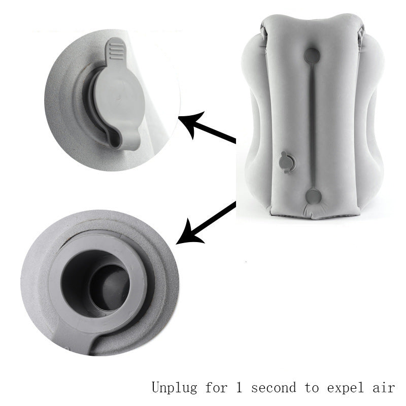 Deflated gray inflatable travel pillow lying flat with close views of the inflation valve and the quick release deflation valve