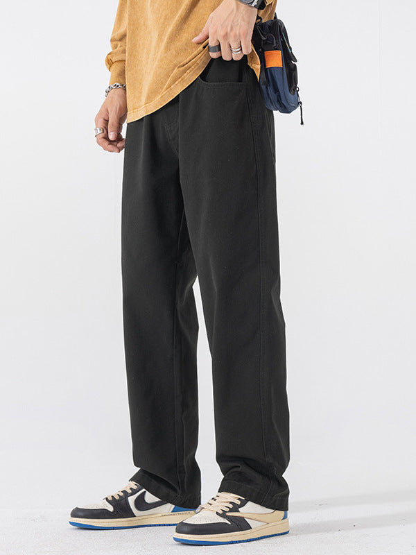 Black straight leg cotton pants worn with a mustard sweater and colorful low sneakers