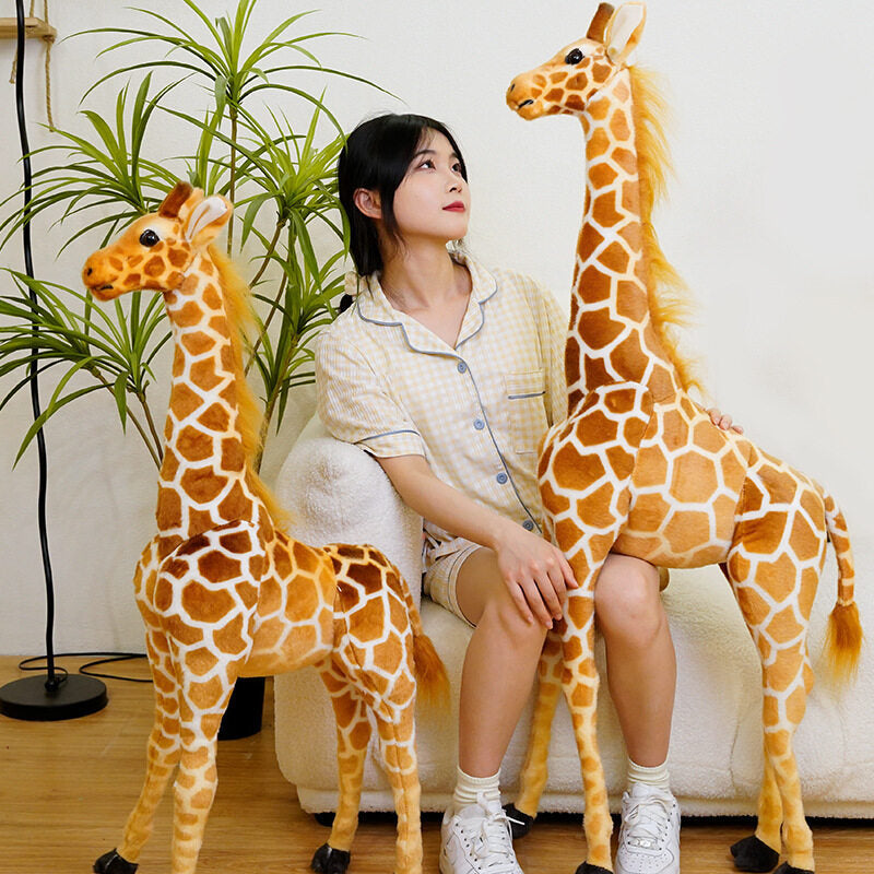 Woman on a white sofa between two tall giraffe plush toys with a smaller one and a leafy plant