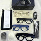 Flat lay of smart glasses frames spare lenses charging cable cloth pouch and manual