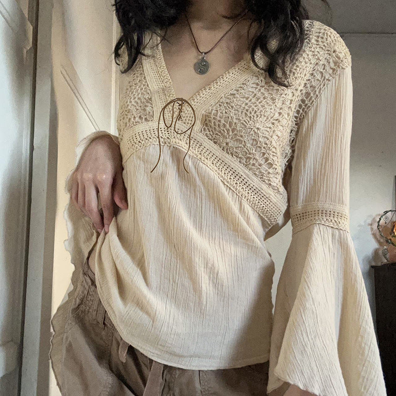 Model wearing the cream crochet lace blouse with cargo trousers, bell sleeves hanging past her hands