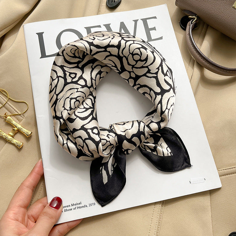 White and black camellia floral printed square scarf with a satin sheen and hemmed edges, shown displayed