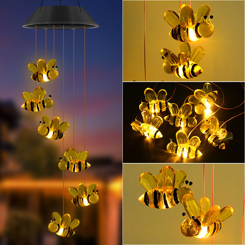 Yellow glowing bee figures hanging from a solar lamp head at dusk, with close-ups of the lit bees