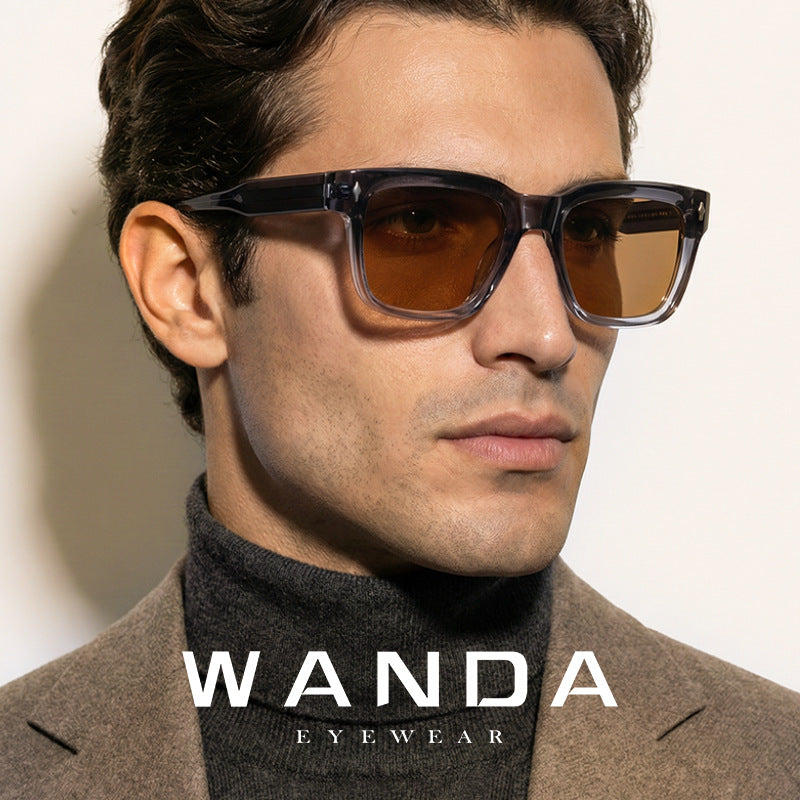 Square acetate sunglasses shown at an angle on a pale surface in warm light