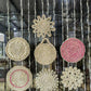 Cluster of woven straw wall ornaments in spiral, sun, and flower shapes