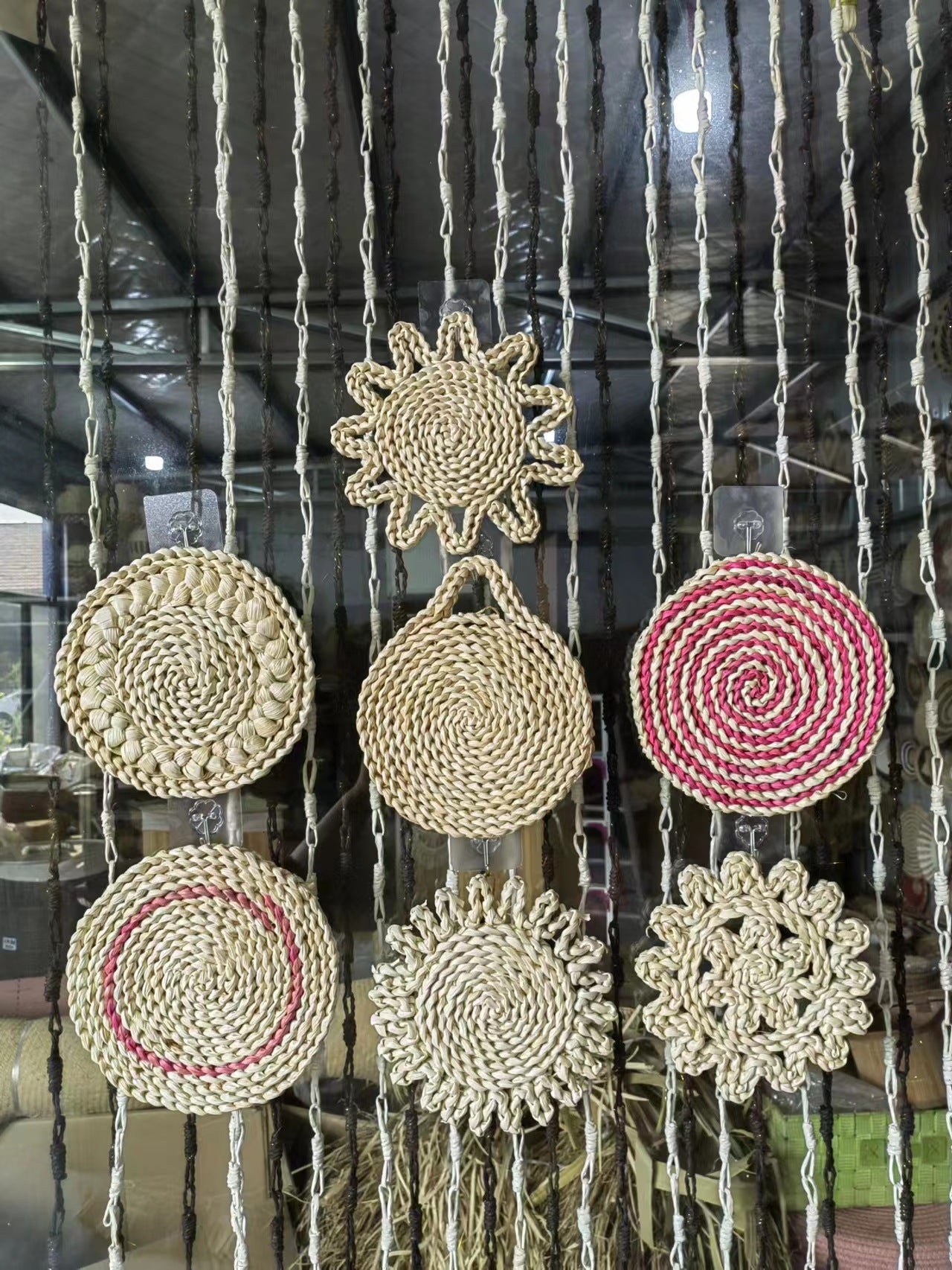 Cluster of woven straw wall ornaments in spiral, sun, and flower shapes