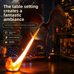 Black winged dragon figure breathing an orange flame stream that glows above a desk with a keyboard and collectibles