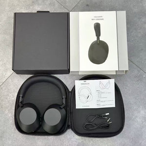 Black over-ear headphones in an open hard zip case beside a gift box, with USB-C and aux cables laid out