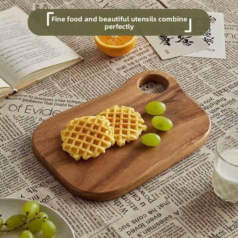 Group of walnut serving boards in different shapes including a large hole and drumstick style