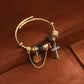 Black colourway gold tone cuff bangle with jet pave bead, faceted black beads, cross charm and safety chain