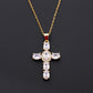 Cross pendant set with green cubic zirconia on a fine gold tone chain, front view
