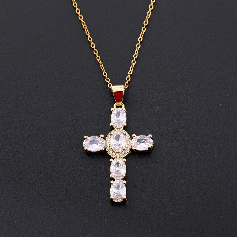 Cross pendant set with green cubic zirconia on a fine gold tone chain, front view