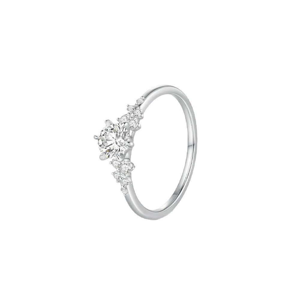 Sterling silver cubic zirconia ring on a finger, bright faceted round center stone catching soft indoor light