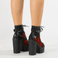 Side view of a lace overlay platform ankle boot showing the tall block heel