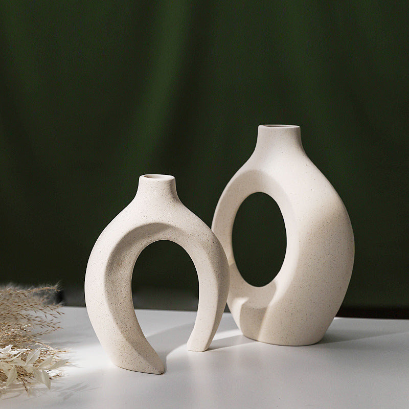 Set of two white nesting ceramic vases with a curved hollow silhouette