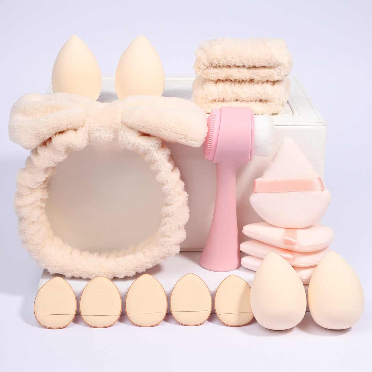 Velvet triangle powder puffs and round puffs beside teardrop foam makeup sponges