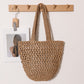 Tan paper straw shoulder bag showing open crochet weave and U-shaped base on a peg rack