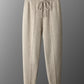 Camel knit drawstring jogger trousers on a hanger with a centre front seam and ribbed ankle cuffs