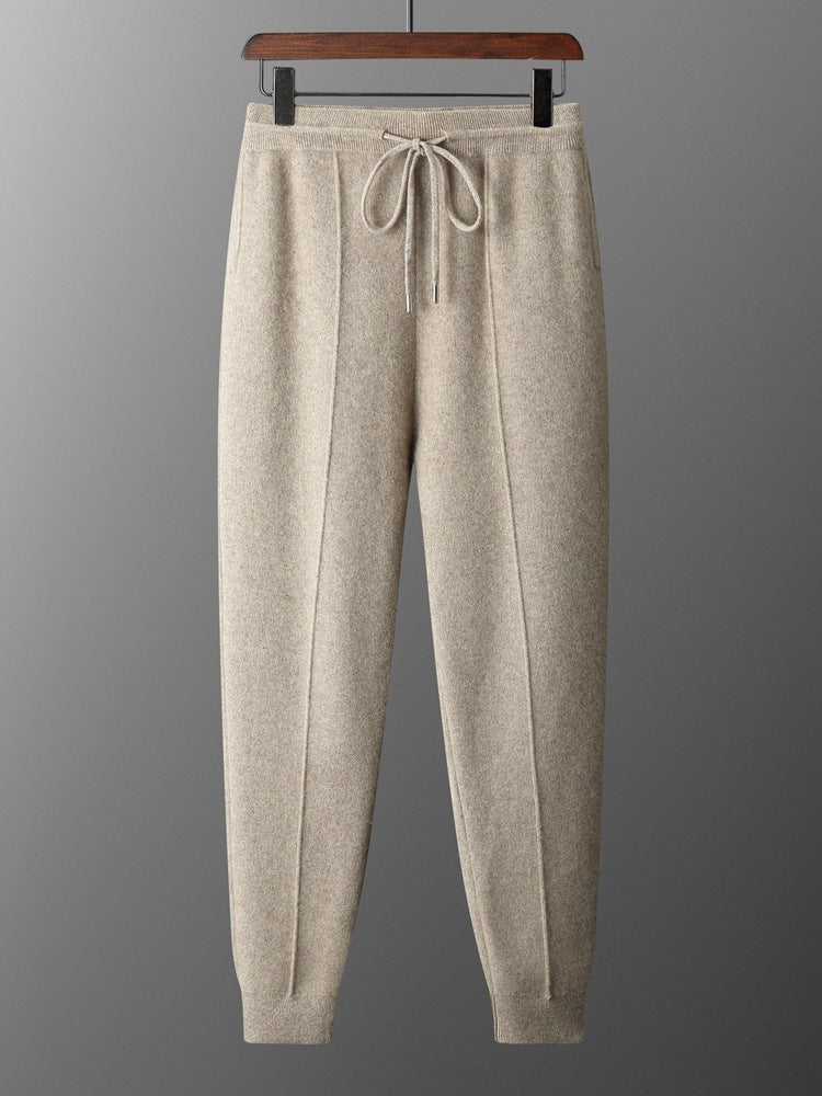 Camel knit drawstring jogger trousers on a hanger with a centre front seam and ribbed ankle cuffs