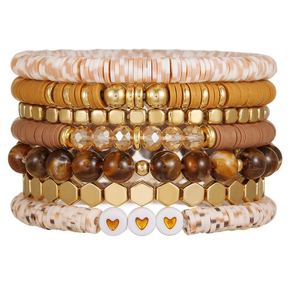Beaded bracelet stack in soft morning light showing clay disc and stone bead rows
