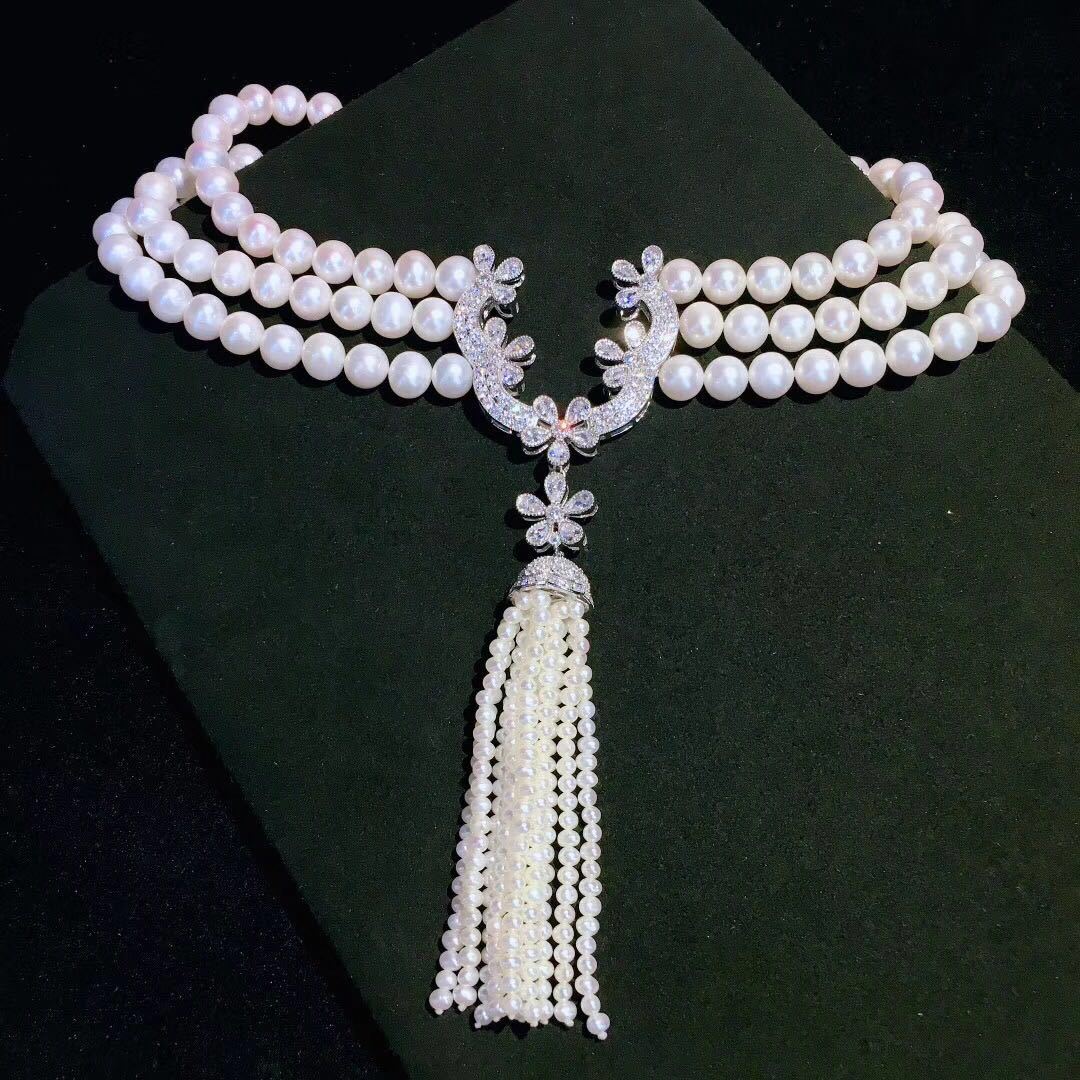 Maker example, the assembled pearl necklace on dark velvet showing the connector at the front