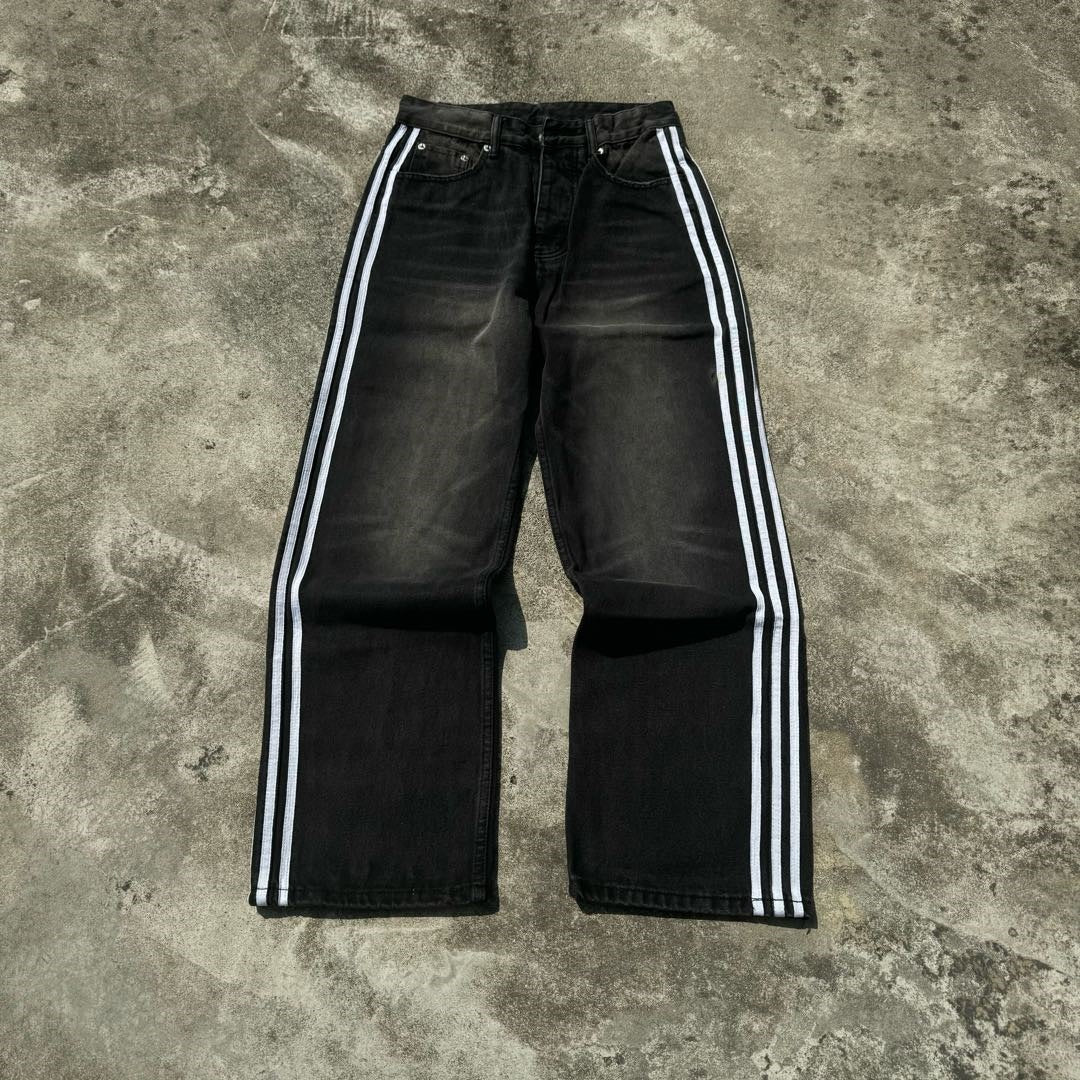Close up of the wide open hem and side stripe of the baggy denim jeans