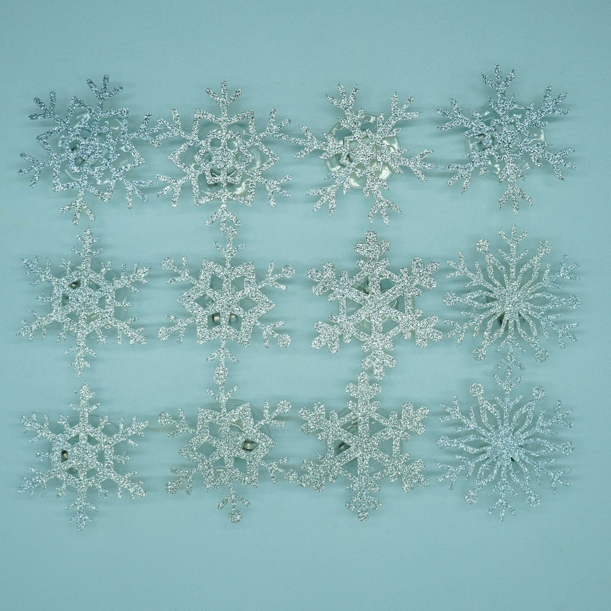 Set of glitter snowflake wall decals shown flat with assorted sizes and geometric shapes