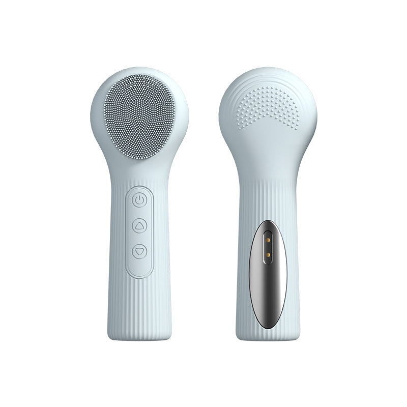 Pink silicone facial brush held in one hand at the bathroom sink