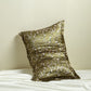 Olive green silk pillowcase printed with white blossom vines, leaning on a cream wall above white silk