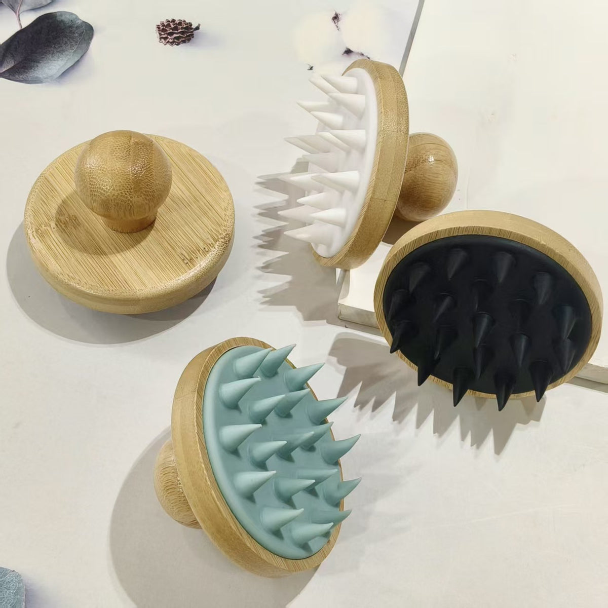 Pink bamboo and silicone scalp massage brush showing the rounded wooden knob handle on the back