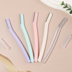 Five eyebrow razors in lilac purple, mint green, pink, white and frosted transparent laid out with two clear caps