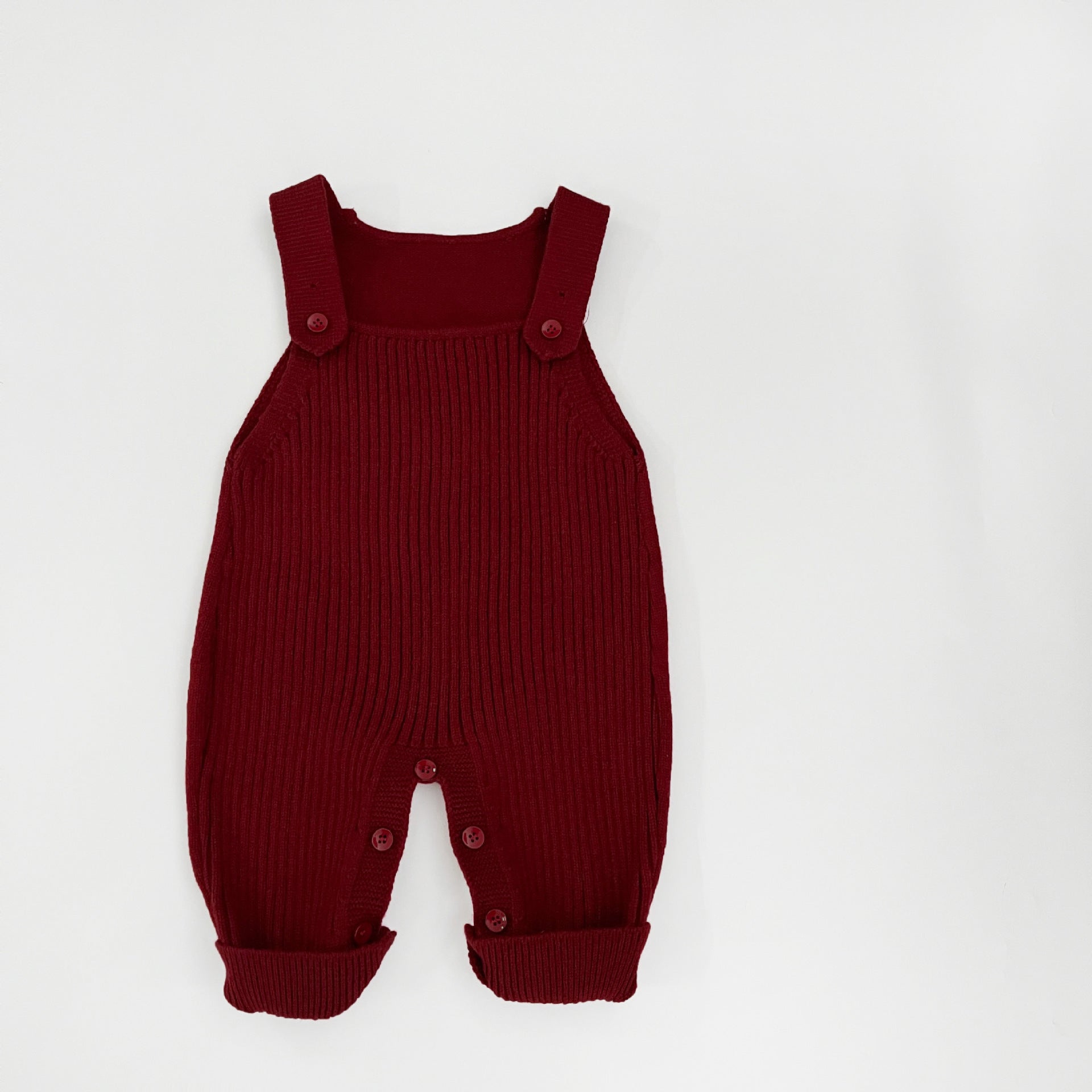 Knit baby dungarees laid flat showing the full front name panel