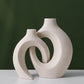 Two nesting ceramic vases tucked together, tall and short curved shapes