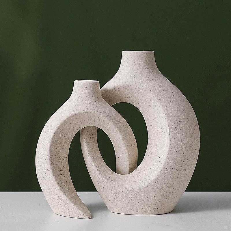 Two nesting ceramic vases tucked together, tall and short curved shapes