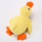 Yellow waffle textured plush duck dog toy with orange beak and feet on a plain light background, extra product photo