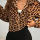 Front view of a leopard print vegan fur jacket half zipped over a white top and black shorts