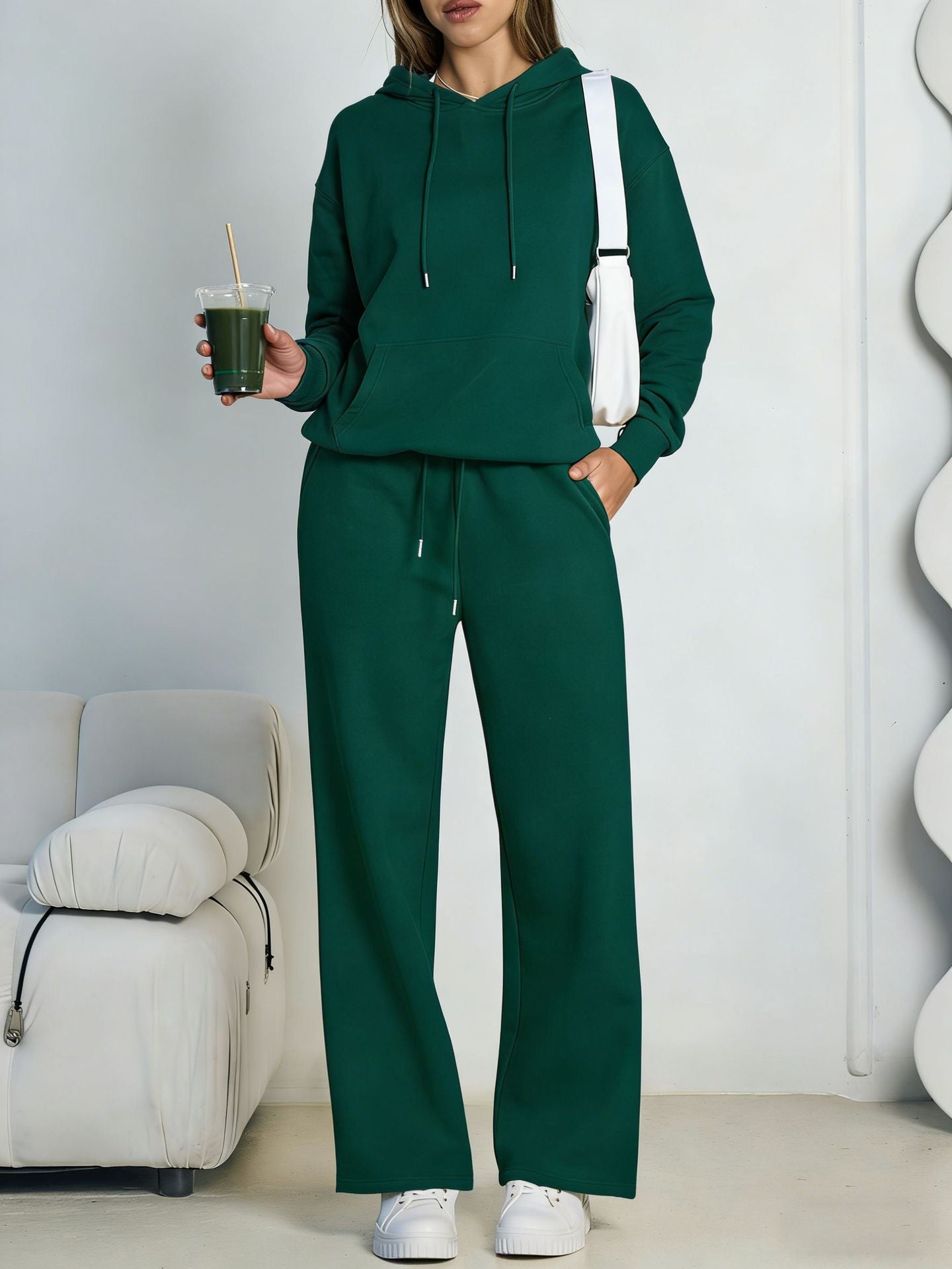 Dark green fleece hooded sweatshirt and wide-leg sweatpants set worn by a model