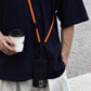 Phone lanyard worn crossbody with the phone hanging at the hip