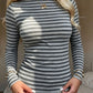 Gray striped long sleeve boat neck top worn with a white skirt, close front view on a model