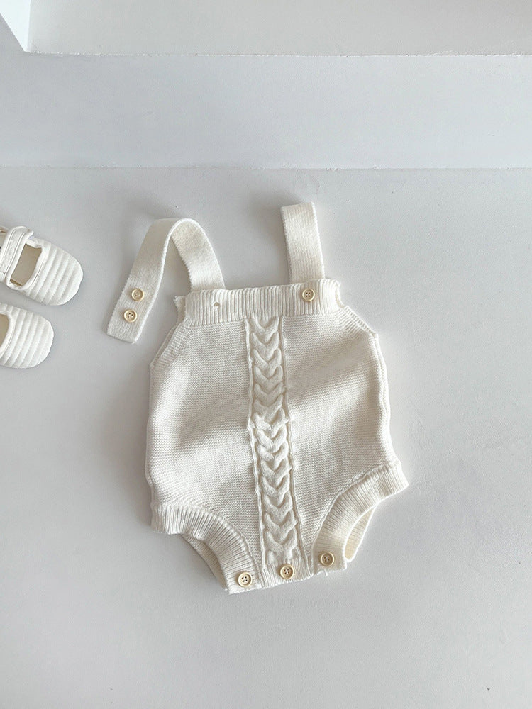 Baby knit cotton romper held to show its small infant size and scale