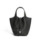 Leather bucket tote bag carried outdoors in a street setting